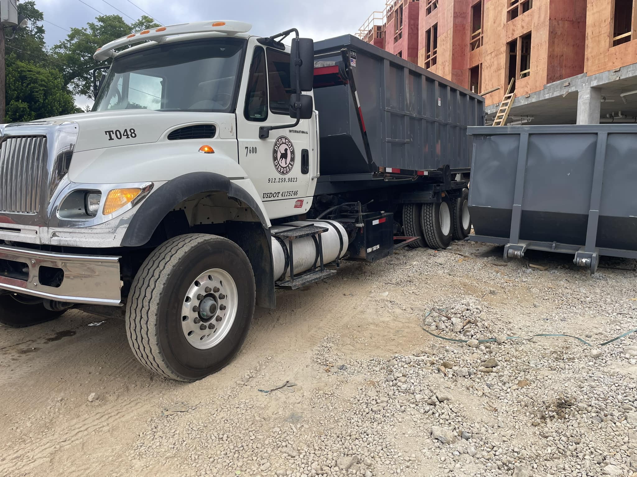 Dogwood Disposal roll-off dumpster delivered on Pooler Georgia commercial site at dusk