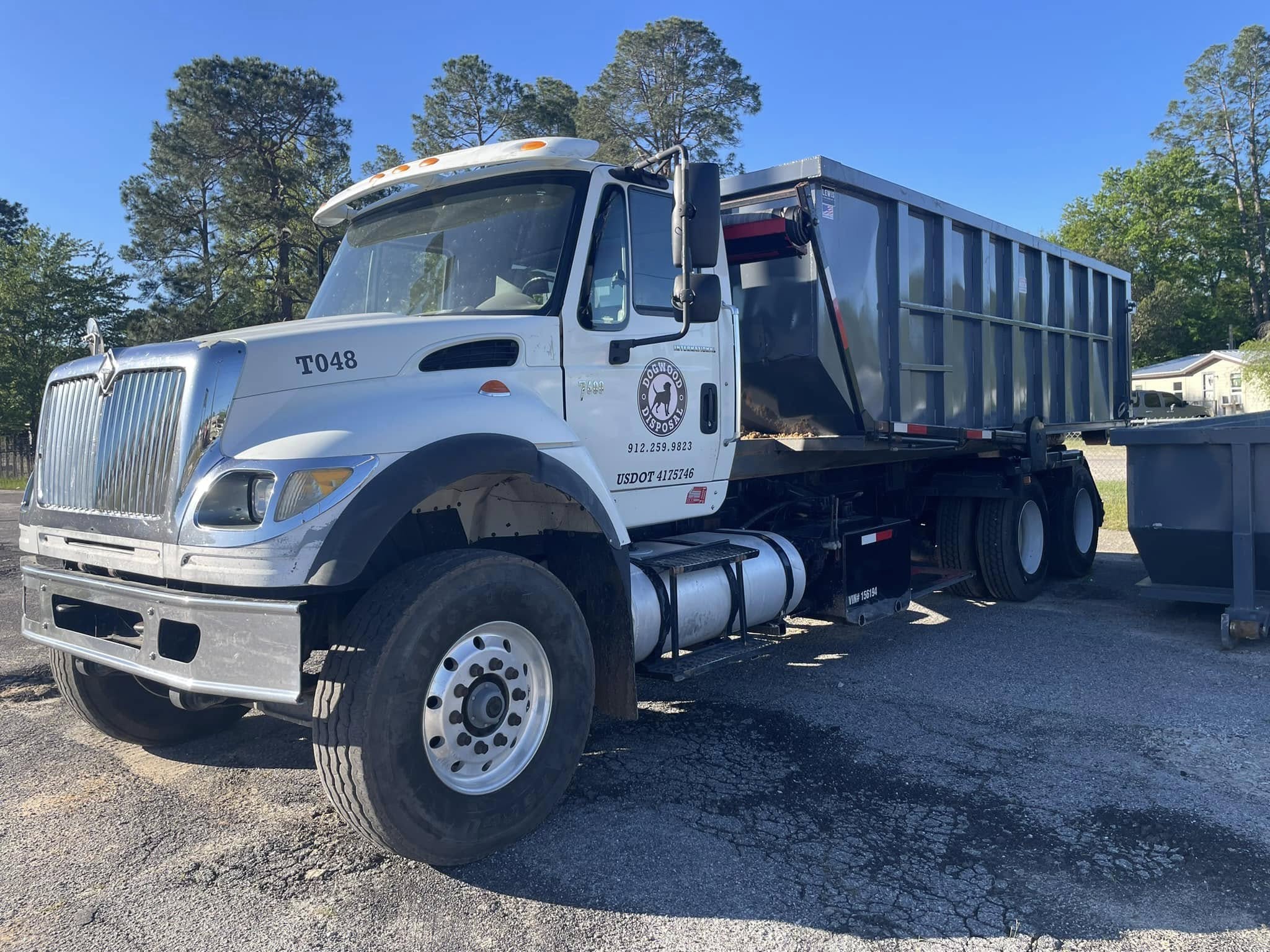Dogwood Disposal red roll-off truck on commercial Metter Georgia US-46 corridor site