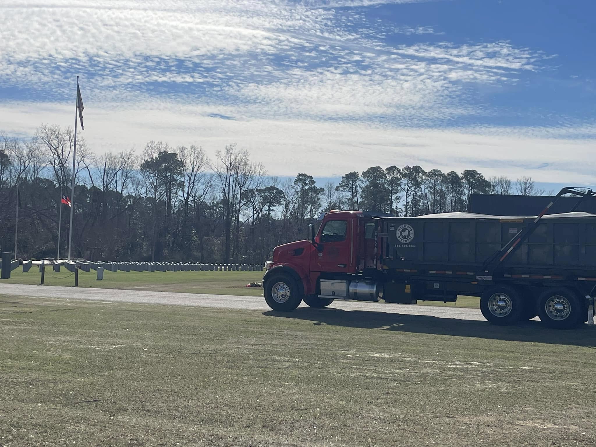 Dogwood Disposal red roll-off truck on commercial Pooler Georgia retail site